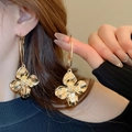 Elegant gold metal flower hoop earrings worn by a model in a high-fashion side profile view - Large 3D Metal Flower Hoop Earring / 16# Silver Needle - Gold
