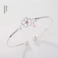 Eleganter silberner Kirschblüten-Armreif mit weißen Blütenblättern und rosa Edelstein - Kirschblüten-Armreif