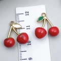 Pair of red cherry alloy pendants with green leaves measured next to a white ruler - Drip Oil Cherry (23408)