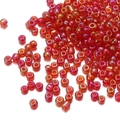 Close-up of small red glass seed beads with iridescent finish for jewelry making - Iridescent Red 165