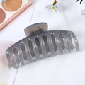 Top view of large translucent grey hair claw clip with interlocking teeth on white fabric - Jelly Grey