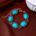 Dettaglio di un bracciale vintage in bronzo e turchese con chiusura a moschettone su tessuto - Bracciale-Oro-Blu