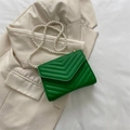 Green crossbody square bag with V-quilted texture and pearl chain strap on beige suit - Green