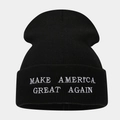 Close-up of white letter embroidery on a black cuffed knit beanie with fine stitching - Black