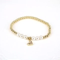 Detailed macro view of gold round beads and white pearl bracelet with heart pendant charm - White