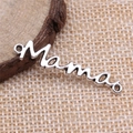 Conector Mama plateado para joyería DIY sobre un fondo tejido con textura - Plata Antigua