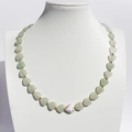 Beaded necklace with light green heart stones and a baroque pearl on a neck display - Pale Green