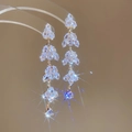 Vue détaillée de boucles d'oreilles dorées à pampilles avec cristaux brillants sur fond beige - Style Pampille Feuille en Zircon Doré (23# Tige en Argent)
