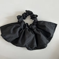 Dettaglio dell'elastico per capelli in tessuto nero con eleganti balze a doppio strato - Nero