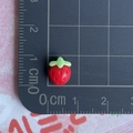Detailed view of a mini 1cm red resin strawberry charm on a centimeter measurement scale - Super Mini Red Strawberry / 1 Piece / Red
