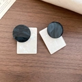 Detail view of square shell and wood bead earrings with marble texture on wooden surface - Black & White Irregular Geometric