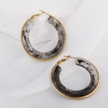 Luxury gold circle earrings with marble resin inlay on white aesthetic stone background - Gray
