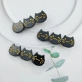 Detailed view of three cute black acetate cat hair clips arranged on a white ceramic plate - Shiny Black