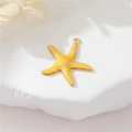 Macro view of gold starfish pendant with textured surface on a white stone base - Gold