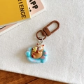 Detail of cute brown bear keychain on blue sofa base with metallic lobster clasp - Sofa Mask Style