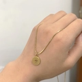 Detail of 18K gold snake chain necklace with an engraved sun eye pendant on the neck - Evil Eye