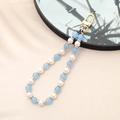 Beaded phone charm with blue Amazonite, white pearls, and gold metal clasp on fabric - Aquamarine Color Natural Stone Beaded Charm (K3506)