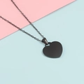 Minimalist heart-shaped pendant necklace in black stainless steel finish on color background - Black
