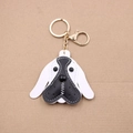 Close-up of beagle dog leather keychain with gold lobster clasp on cardboard backing - Black and White