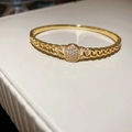 Détail d'un bracelet à maillons dorés orné d'une boucle ronde en oxyde de zirconium - Chaîne Cubaine Pavée / Or