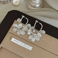 Detailed close-up of silver geometric sequin petal tassel earrings on silk background - Silver (Silver Pin)