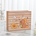 Horizontale Geschenktüte aus Papier mit Bär und Löwe Motiv und weißen Griffen auf Marmor - Wasserschwein 1