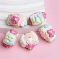 Macro shot of colorful resin beads with cream cake and flower designs on a white stone - White Bead Pink White Cream Green Hi Pink Flower