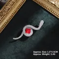 Detailed close-up of a silver snake brooch with red gemstone on green velvet - Silver Snake with Red Gem (XZ24172)