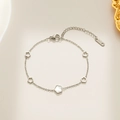 Silver titanium steel bracelet featuring five white shell flowers and an 18KGP tag - Silver