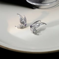 Silver liquid metal butterfly wing stud earring with purple zircon on white ceramic plate - Butterfly Wing With Purple Zirconia / Silver