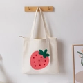 Off-white canvas tote bag featuring large red strawberry embroidery and zip closure - Off White