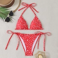 Close-up of red floral bikini set with halter top and side-tie bottoms on beach props - S / Red