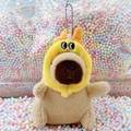 Cute brown plush capybara keychain with a bright yellow character hood on a colorful background - Dragon Horn Hat Light Brown + Bead Chain