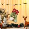 Detail of green burlap Christmas stocking with plush gnome and HO HO HO label on a branch - Light Green
