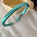 Close-up of glossy cyan satin fabric headband featuring a handmade inner label detail - Lake Blue