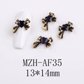 Macro shot of 13x14mm gold bow and black heart alloy nail art charms on white nail - AF35-Gold Edge Black Rhinestone Large Bow