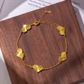 Detail of gold bracelet featuring heart charms with radial texture on a wooden stand - Heart Bracelet