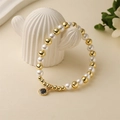 Bracelet tendance perles dorées et perles blanches avec un pendentif rond scintillant - Pendentif Rond en Strass Noir