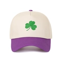 Detailed close-up of green clover embroidery on a color-block panel baseball cap - Beige Crown + Purple Brim