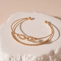 Detailed macro view of gold-plated double-layer bangle with pavé-set cubic zirconia accents - Double Layer Link Chain Open Bangle / Gold