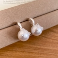 Macro shot of pearl earrings with cross star zircon accents on a beige display - Silver (Silver Pin)