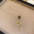 Detail of a rocking horse necklace with tiger eye beads and white zircon micro-inlays - Gold Brown
