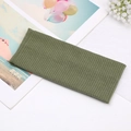 Olive green ribbed knit headband featuring a twisted knot and elastic crossover design - Green