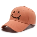 Orange cotton baseball cap with embroidered smiley face in a front-side view - Adjustable / Orange