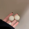 Macro shot of vintage round floral stud earrings with beige resin and gold metal trim - Round / Cream White