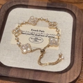 Elegant gold clover bracelet with white mother of pearl and zircon stones on display - Gold/White