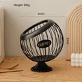 Black spherical iron coffee pod holder with decorative COFFEE plaque on a wooden surface - Elevated Style: Classic Black Basket