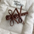 Detailed view of the dark brown faux leather bow hair clip with woven texture and metal base - Dark Coffee