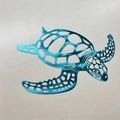 Close-up of blue hollow-out metal sea turtle wall art with intricate decorative details - Blue