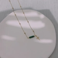 Détail du collier doré avec perles de malachite et pendentif étoile sur plateau céramique - Collier Étoilé (DS006星光-项链)